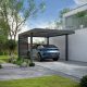 Carport aluminium moderne Odyssée installé devant une maison contemporaine, abritant un véhicule électrique en cours de recharge.